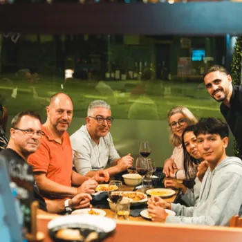 Le patron et des clients partageant un plat de gambas